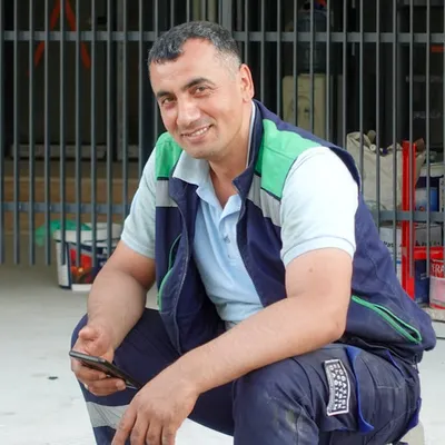 Contractor checking a blurred business site on a phone at a job site; mobile-first, in the field.