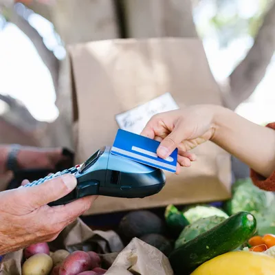 Payment card on clipboard with blurred invoice; close the loop after the job.